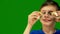 Portrait of Caucasian preschool boy holding sushi in hands on green background. Child sniffs and adores sushi. Green screen. Selec