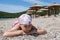 Portrait of Caucasian pretty girl sleeping on sand in swimwear and scarf on head. Seashore with parasols