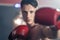 Portrait of Caucasian professional shirtless male athlete wear boxing gloves, practice hitting and punching to maintain muscle. Ac