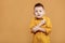 portrait of caucasian scared child boy on yellow background. amazed stressed boy in yellow shirt. school child afraid or