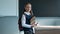 Portrait of a caucasian schoolgirl with a backpack. The girl is holding a stack of textbooks in the classroom.