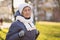 Portrait Caucasian senior woman with gray hair and deep wrinkles 90 years old posing in warm clothes, white knitted scarf and hat