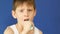 Portrait of a caucasian sleepy tired boy 7 years old brushing his teeth after sleeping. A sleepy, irritated schoolboy washes his f