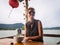 Portrait of a caucasian travel woman sitting in a cafe in Vietnam holding mobile phone to make a selfie