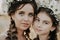 Portrait of Caucasian white mother with her daughter with braids and wreaths in the summer outdoors