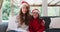 Portrait of caucasian woman and daughter smiling and waving looking at the camera while sitting on t