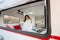 Portrait of a caucasian woman looking out of a trailer window. Travel in a camper in autumn.