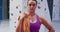 Portrait of caucasian woman with rope over her shoulder preparing for climb at indoor climbing wall