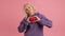 Portrait caucasian woman shows heart sign and holds red heart in her hands, makes symbol with her hands, feels grateful