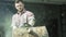 Portrait of caucasian young man worker sawing a log with a chainsaw. Video. Male carpenter sawing a part of tree trunk