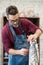 Portrait of Ceramist Dressed in an Apron Working on Clay Sculpture in Bright Ceramic Workshop.