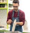 Portrait of Ceramist Dressed in an Apron Working on Clay Sculpture in Bright Ceramic Workshop.