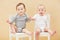 Portrait, chair and baby boys for growth or child development in studio on an orange background. Children, cute or