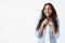 Portrait of charismatic and charming African-American woman with long wavy hair wearing stylish denim shirt, smiling