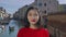 Portrait of charming asian girl smiling and posing for the camera on the background of a beautiful Venetian canal