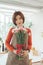 Portrait of charming Asian Korean Woman florist holding a bouquet flowers in hands