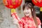 Portrait charming beautiful asian woman wear cheongsam dress gets red envelopes from her family. Pretty girl shows red envelopes.