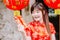Portrait charming beautiful asian woman wear cheongsam dress gets red envelopes from her family. Pretty girl shows red envelopes.P