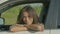 Portrait of charming black female driver in car looking with radiant smile