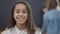 Portrait of charming confident smart African American schoolgirl with toothy smile posing in classroom with blurred