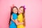 Portrait of charming girls enjoy summer weekends close eyes true buddies isolated over pink background