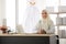 Portrait of charming muslim female doctor working at office desk and smiling at camera