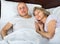 Portrait of charming ordinary mature couple napping in bed