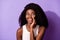 Portrait of charming positive dark skin lady hand near mouth speak look empty space isolated on purple color background