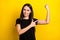 Portrait of charming positive girl indicate finger hand flex show biceps isolated on yellow color background