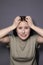 Portrait of charming scared brunette woman in marsh color t-shirt on grey wall background. actress acting, emotion