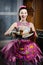 Portrait of charming sincere funny pinup girl in a dress apron having fun happy smiling baking tasty cake