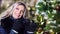 Portrait of charming smiling woman wearing amazing evening makeup posing near Christmas tree