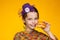 Portrait of a cheerful 8-year-old girl in a miniature hat, a multi-colored sweater and with a sandwich in hand