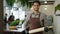 Portrait of cheerful Afro-American guy in apron holding rolling pin in cookery class