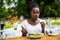 Portrait of cheerful afro american woman has dinner break, eats fresh salad dish in cafe.