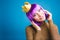 Portrait cheerful amazing young woman with cut purple hair, golden crown, luxury dress on blue background. Celebrating