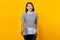 Portrait of Cheerful Asian woman bring laptop over yellow background