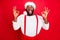 Portrait of cheerful black santa claus showing ok sign screaming wearing cap white sweater isolated over red background