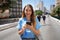 Portrait of cheerful Brazilian girl using mobile phone on Minhocao highway on sunday, Sao Paulo, Brazil