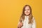 Portrait of a cheerful child in a beige jacket on a yellow background. Little girl blonde looks into the camera. Autumn concept.