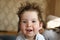 Portrait of a cheerful child with tousled hair. child 1-2 years old