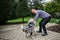 Portrait of cheerful down syndrome adult man playing with dog outdoors in backyard.