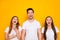 Portrait of cheerful fellows laughing touching chest wearing white t-shirt isolated over yellow background