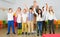 Portrait of cheerful female teacher with her happy schoolkids in classrom