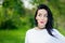 Portrait of a cheerful girl in nature. with black hair and painted hoods in a white T-shirt. natural emotions. Beautiful smiling