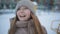 Portrait cheerful girl in winter hat and jacket looking around on snowy city. Close up happy face laughing teenager girl