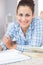 Portrait of cheerful gorgeous student lying on the floor doing assignments