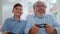 Portrait of cheerful grandson and grandfather playing video game in living room