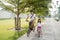 A portrait of a cheerful and happy little girl riding a bicycle with her father in the park