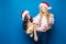 Portrait of cheerful happy women in christmas hats while standing and looking at camera isolated over blue background